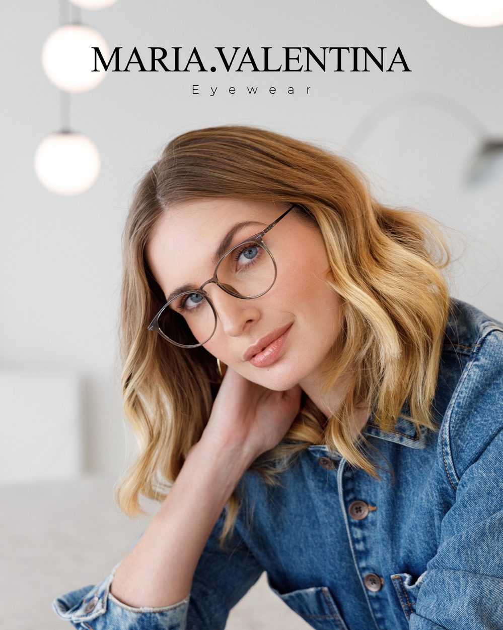 Mulher de jaqueta jeans usando óculos de grau Maria Valentina